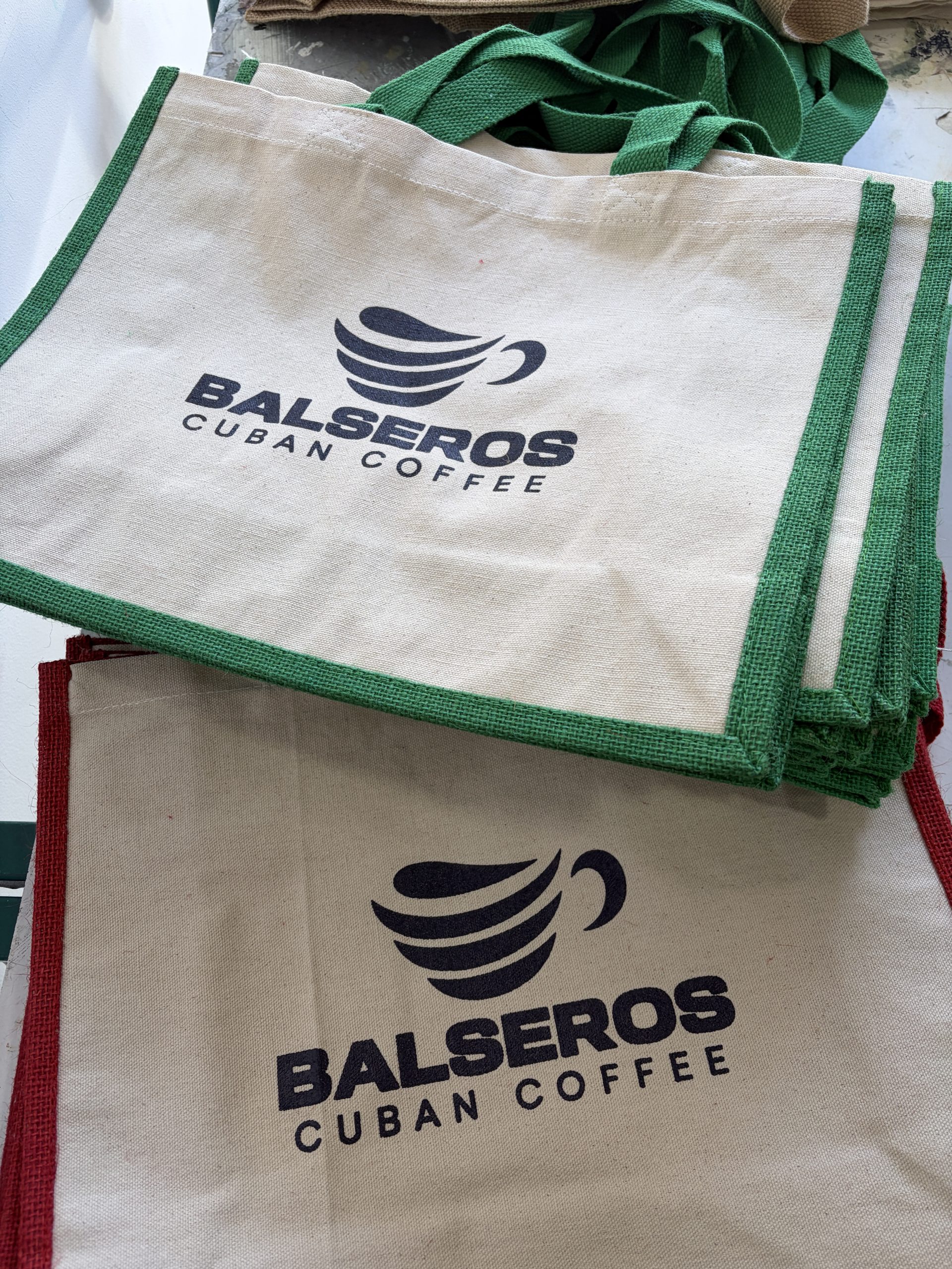 Bolsas reutilizables de tejido natural con asas verdes y logotipo impreso