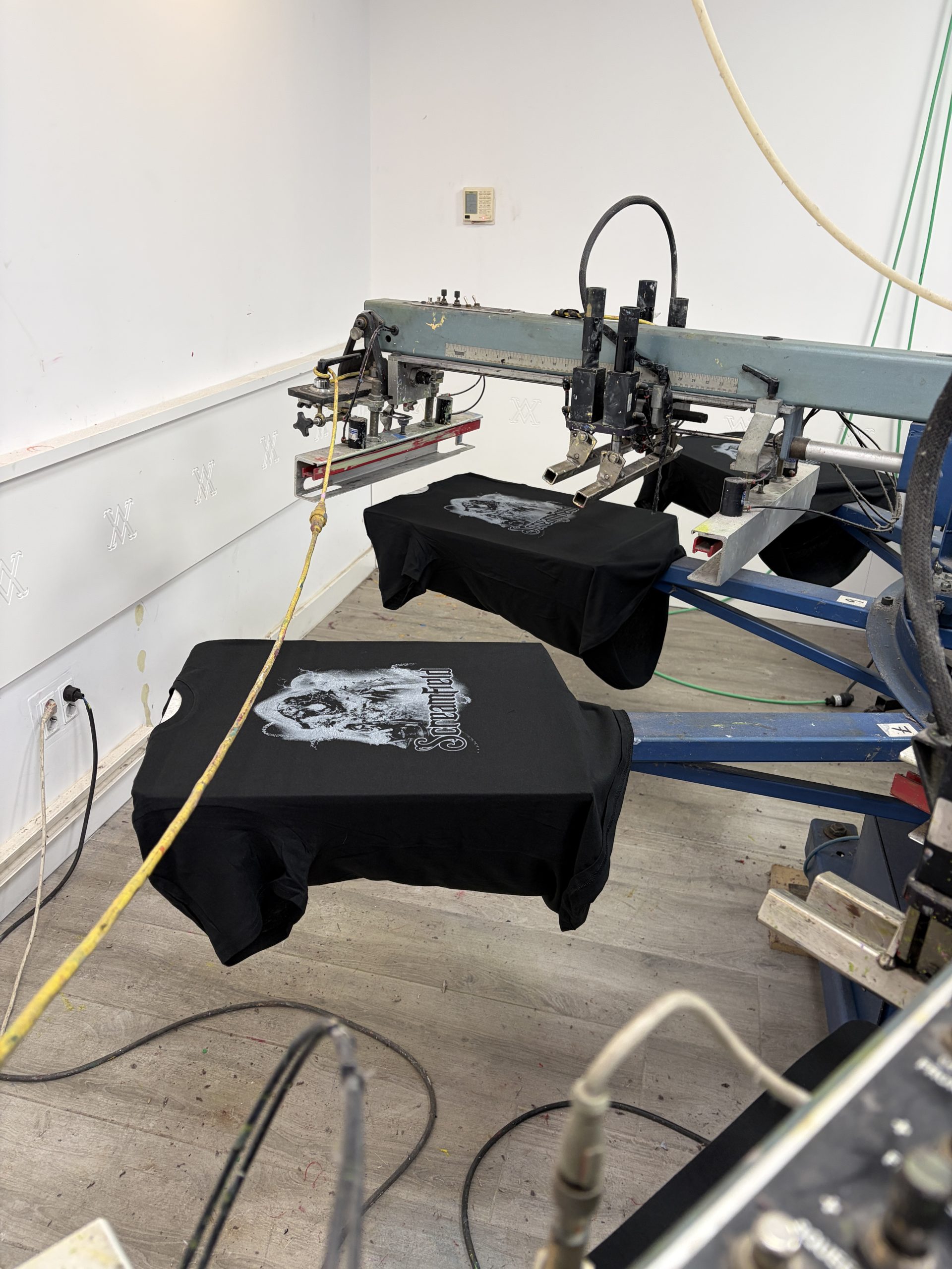 Camisetas negras en un carrusel de serigrafía del taller de MarcaTuLogo